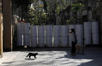 A woman walks her dog next to a barricade at the UN-controlled buffer zone in Nicosia, Cyprus. Reuters