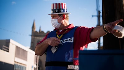 John Eddy, 52, gestures as he collects absentee ballots from voters as they drive past the Cuyahoga County Board of Elections in Cleveland, Ohio. AFP