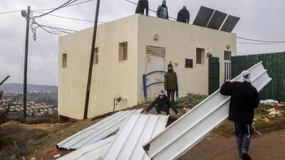 Israeli youth block the entrance of the Amona settlement on December 15, 2016. The outpost, which was established in 1997, is under a high court order to be evacuated by December 25 since it was built on private Palestinian land. Jack Guez / AFP