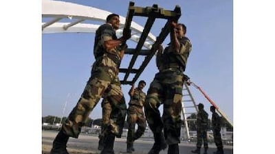 Indian soldiers work to rebuild the collapsed pedestrian bridge outside the Jawaharlal Nehru Stadium. Adnan Abidi / Reuters