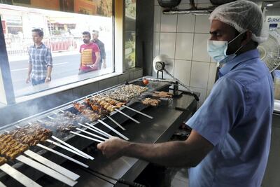 A chef prepares chicken and mutton for the lunchtime rush. Pawan Singh / The National