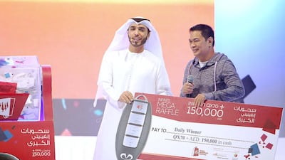 Joel Gutierrez collects his prize – the keys to a new Infinity QX70 and Dh150,000 in cash, at the Dubai Shopping Festival. Courtesy DSF