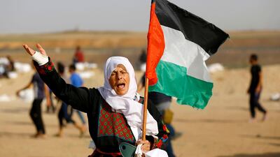A Palestinian woman holds her national flag during a protest along the border with the Gaza strip east of Jabalia. Mohammed Abed / AFP