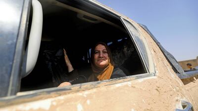Sawsan Karapetyan, one of the few Christians left in Raqqa, finally escaped and now smiles from the safety of a car taking her to Jazra, a western suburb of the northern Syrian city, on August 8, 2017. Delil Souleiman / AFP
