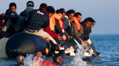 Migrants attempt to board an inflatable dinghy leaving the coast of northern France to cross the English Channel to reach Britain. Reuters