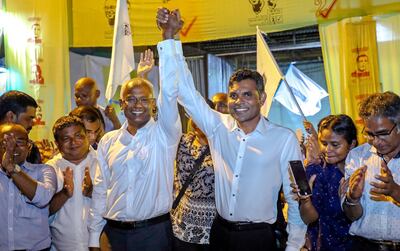 Maldives' opposition presidential candidate Ibrahim Mohamed Solih, third left, and his running mate Faisal Naseem, third right, pose for photographers as they celebrate their victory in the presidential election in Male. AP
