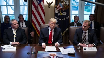 US President Donald Trump speaks in front of a poster that reads "Sanctions Are Coming" during a meeting in White House. Al Drago / Bloomberg