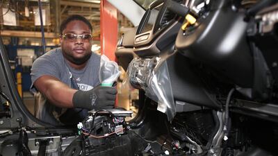 Wilhem Sandeau of Detroit, Michigan installs a shifter in a 2014 Jeep Cherokee. Bill Pugliano / Getty Images / AFP