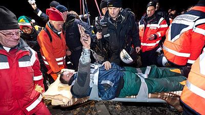 A protester flashes the victory sign as he is carried off rail tracks where he and other activists chained themselves to the track to delay a transport of reprocessed nuclear waste from France to a storage facility in Gorleben during a protest in Hitzacke???
