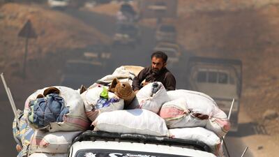 Displaced Syrians who fled from regime raids ride in trucks with their belongings arrive near a camp in Kafr Lusin near the border with Turkey in the northern part of Syria's rebel-held Idlib province. AFP