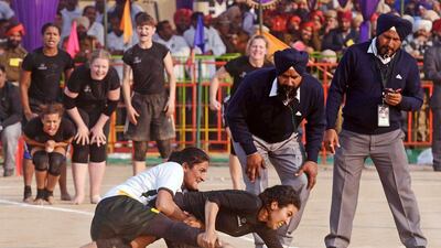 A Danish kabaddi player, centre right, is tackled by her Pakistani opponent during the Kabaddi World Cup in Chohla Sahib, India, on Monday. Kabaddi, a team sport that originated in the Indian sub-continent, involves team members making 'raids' into the opposing team's territory on a playing field in an attempt to 'tag' opponents while holding one's breath and chanting the word 'kabaddi'. Narinder Nanu / AFP
