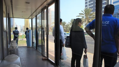 Commuters stand outside a bus stop with faulty air-conditioning near Madinat Zayed on Muroor Road. Ravindranath K / The National