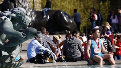 A runner cools his feet in the water features of Trafalgar Square after taking part in the London Marathon April 13, 2014. REUTERS/Eddie Keogh