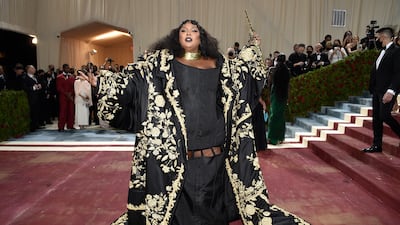 Musician Lizzo wearing a black Thom Browne gown with gold detail. AP Photo