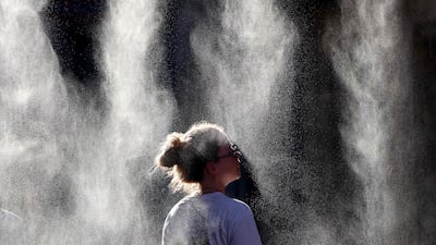 A woman cools off under a mist sprayer during a heatwave in Bordeaux. AFP
