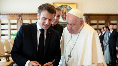 Pope Francis exchanges gifts with French President Emmanuel Macron during a private audience at the Vatican. AFP