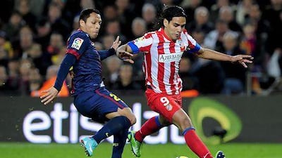 Barcelona's Adriano Correia, left, takes on Atletico Madrid's Radamel Falcao Garcia at the Camp Nou stadium in Barcelona. Etisalat has extended its sponsorship of FC Barcelona for another four years. Josep Lago / AFP