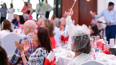 A woman waving the British flag during the live screening of King Charles' coronation at Queen Elizabeth 2, Port Rashid in Dubai. Khushnum Bhandari / The National