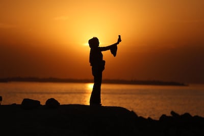 A woman with her mobile phone near Al Shatee refugee camp, west of Gaza city. AFP