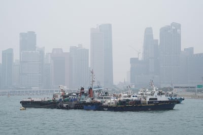 Buildings stand shrouded beyond anchored boats in Singapore on Wednesday as the air quality level in the city-state turned unhealthy. Dimas Ardian / Bloomberg