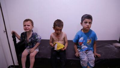 Syrian children wait to receive treatment at a makeshift hospital after they were injured in shelling on the rebel-held town of Arbin on July 24, 2017. AFP / Abdulmonam Eassa