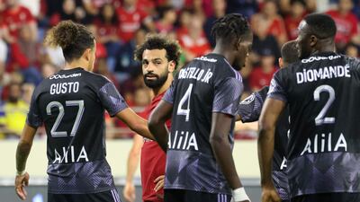 Mohamed Salah watches as Lyon's players celebrate scoring. AFP