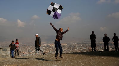 An Afghan boy launches a kite as he plays on top of a hill in Kabul. Mohammad Ismail / Reuters