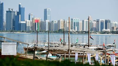 Dhows and other boats decked out in UAE flags, by the Heritage Village. Khushnum Bhandari / The National