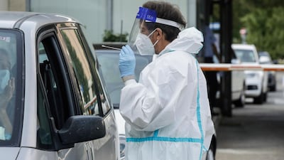 A medical worker in Milan takes swabs to test for Covid-19 for people returning from Croatia, Spain, Malta and Greece. AP
