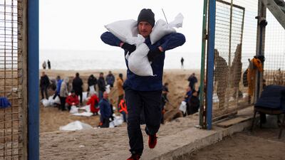 On Sobachyy beach, Oleksandr Hotovcev, 34, carries sandbags to bolster city defences in Odesa, Ukraine. Reuters