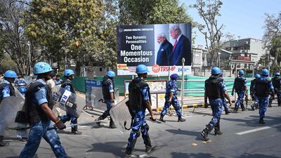 Rapid action force (RAF) personnel patrol along a street past a billborad displaying pictures of India's Prime Minister Narendra Modi and US President Donald Trump in Ahmedabad, ahead of Trump's arrival. AFP
