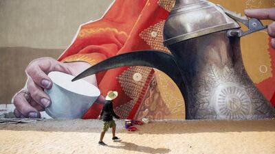 One of the group of artists works on the huge mural near Al Raha Mall in the Raha Beach area of Abu Dhabi. Christopher Pike / The National
