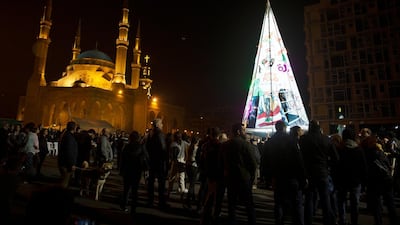 Anti-government protesters gather around their Christmas tree, which incorporates protest iconography and slogans and personal messages from protesters at the base, at a celebration in downtown Beirut. AP Photo