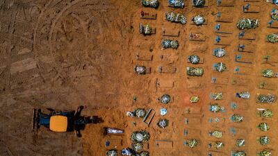 A tractor digs graves in a new area of the Nossa Senhora Aparecida in Manaus, Brazil. AFP