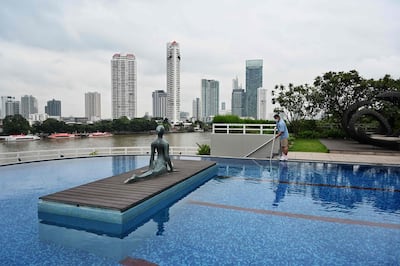 Staff clean the pool at the Chatrium Hotel Riverside Bangkok, as Thailand’s battered tourism industry prepares for the second relaxation of Covid-19 travel restrictions. AFP