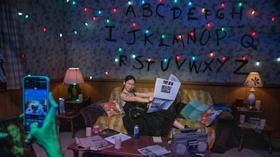 A woman poses for a picture in the mix-tape room after taking part in Stranger Things: The Experience in New York in 2022. EPA