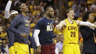 Cleveland Cavaliers' JR Smith, left, LeBron James and Timofey Mozgov react on the sidelines late in the second half of Game 4 of the NBA basketball Eastern Conference Finals against the Atlanta Hawks on Tuesday, May 26, 2015, in Cleveland. The Cavaliers won 118-88. (AP Photo/Tony Dejak)