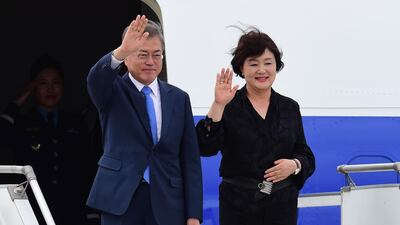 South Korea's President Moon Jae-in (L) and his wife Kim Jung-sook, wave upon arrival at Ezeiza International airport in Buenos Aires province, on November 29, 2018. Global leaders gather in the Argentine capital for a two-day G20 summit beginning on Friday likely to be dominated by simmering international tensions over trade. / AFP / MARTIN BERNETTI