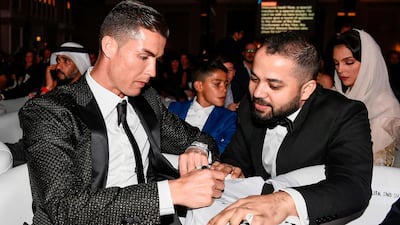 Juventus' Portuguese forward Cristiano Ronaldo signs an autograph for a fan during the 10th edition of the Dubai Globe Soccer Awards in Dubai. AFP