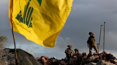 Israeli soldiers stand guard next to cameras at their new position in front of a Hezbollah flag. AP Photo