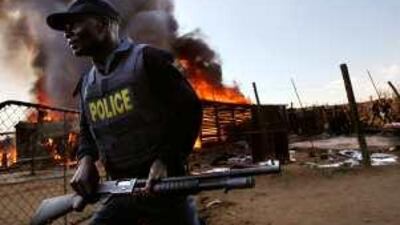 Homes burn in the shanty town of Reiger Park in May 2008. Violence and concerns about the stability of the country's governance are among concerns expressed in the survey.