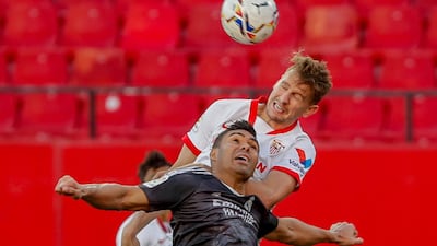 Sevilla's Luuk de Jong, top, vies for the ball with Real Madrid's Casemiro. AP