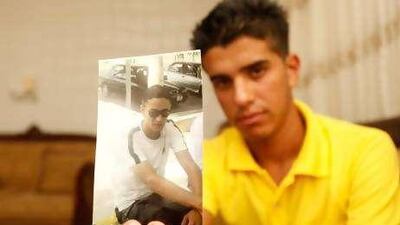 Ahmad Nabham holds a picture of his cousin Hussam, killed by a celebratory gunshot.