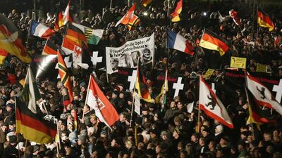 Supporters of anti-immigration movement Patriotic Europeans Against the Islamisation of the West (PEGIDA) hold flags during a demonstration in Dresden (REUTERS/Fabrizio Bensch)