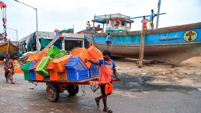 A fisherman pulls a handcart filled with crates towards inland ahead of a cyclonic storm that may hit the North Maharashtra and Gujarat coast, at the Madh fishing village, in the north western coast of Mumbai on June 2, 2020. AFP