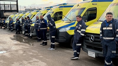 Paramedics wait on the Egyptian side of the Rafah border crossing with the Gaza Strip on Wednesday. Reuters