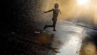 A girl runs through a sprinkler at a playground in the Brooklyn borough of New York July 7, 2014. Reuters
