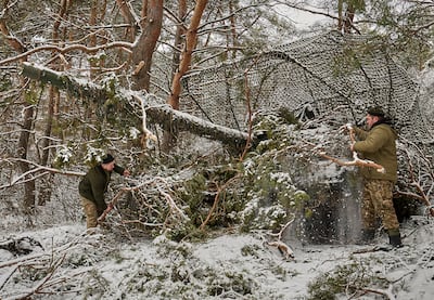 Ukrainian troops camouflage their tank on the front line. EPA