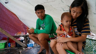 Leahmer Singson with her son and partner, Jay Rabina, in their tent in Mambaling, Cebu, central Philippines on New Year's Eve. AP