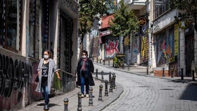 Istanbul residents walk along a quiet street in the city after Turkish authorities urged people to avoid socialising during the outbreak. EPA
